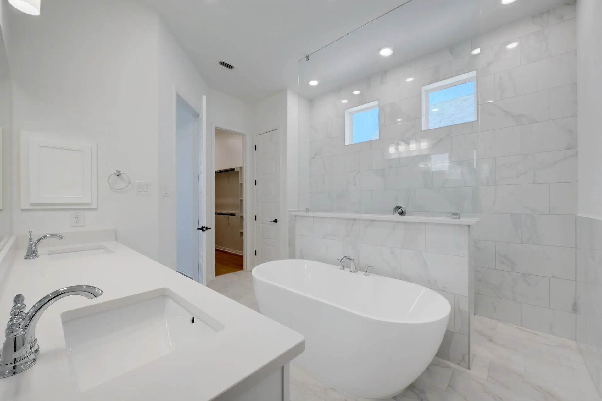 A white bathroom with a tub and sink.