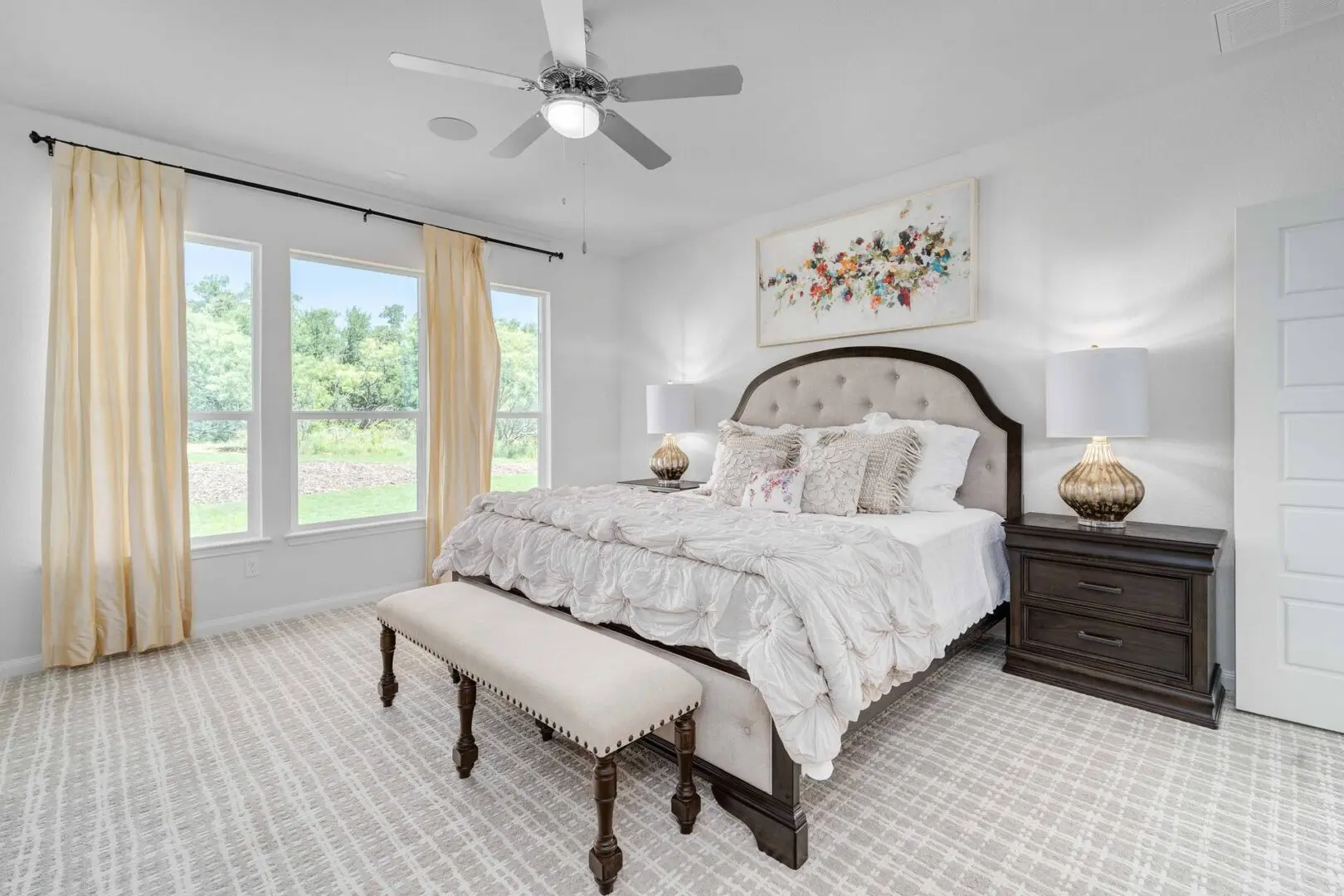 A bedroom with a bed, dresser, and ceiling fan.