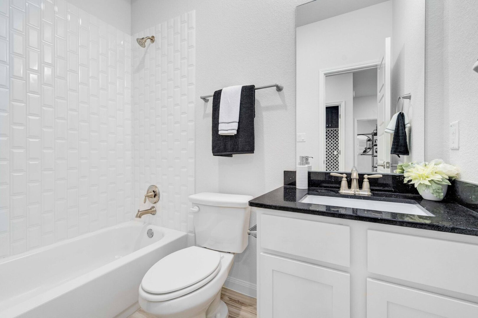 A white and black bathroom with a toilet and sink.