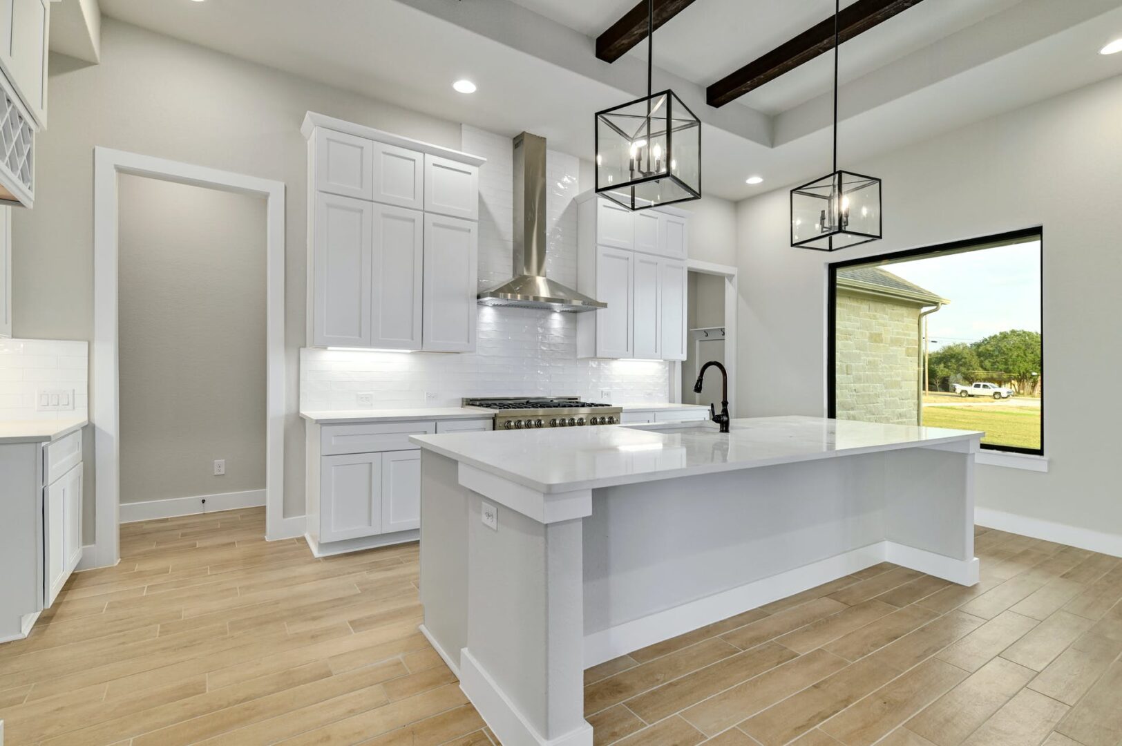 A white kitchen with wood floors and a center island.